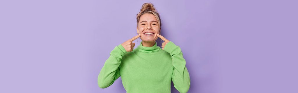 Girl showing their healthy teeth with dental bridge